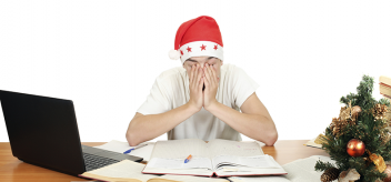 Sleepy student wearing santa hat while studying