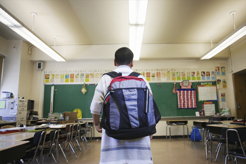 boy wearing backpack in school