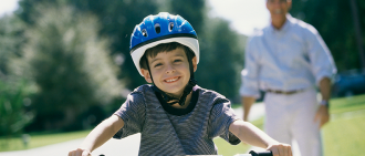 孩子骑着带头盔的自行车