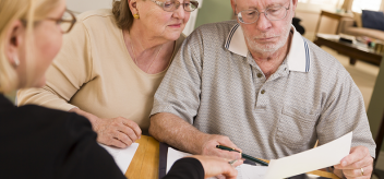 elderly couple looking at papers
