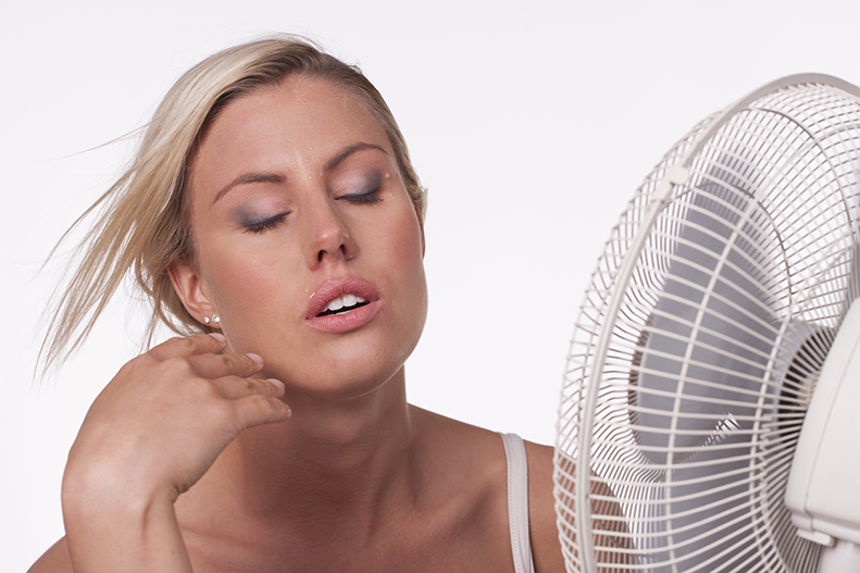 woman cooling off in front of fan
