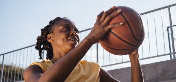 Young woman playing basketball outdoors