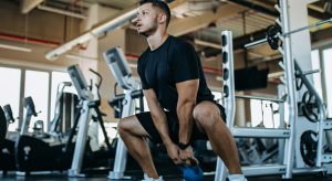 Man doing squats at gym.