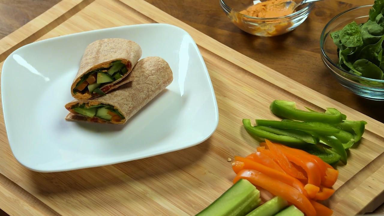 我们把灯笼椒和菠菜切成片，做成这道简单的午餐。试试我们的蔬菜鹰嘴豆泥包食谱。